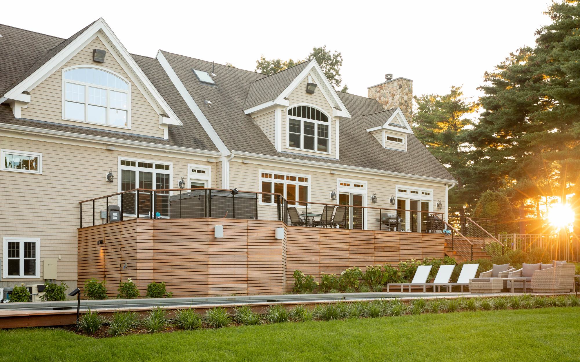 Sharon Landscape — golden-hour rear elevation with sun flare through the trees