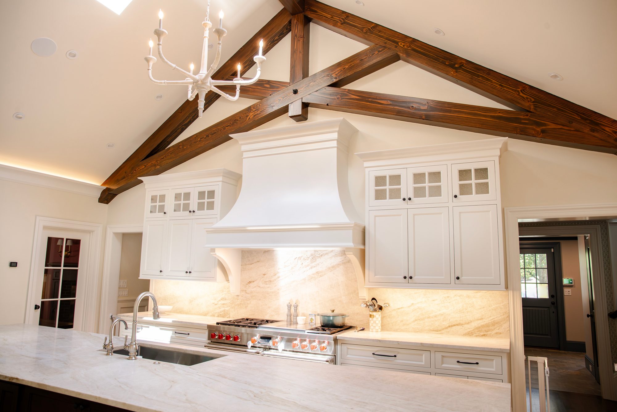 Wellesley Renovation — custom kitchen with marble backsplash, range, and beamed cathedral ceiling