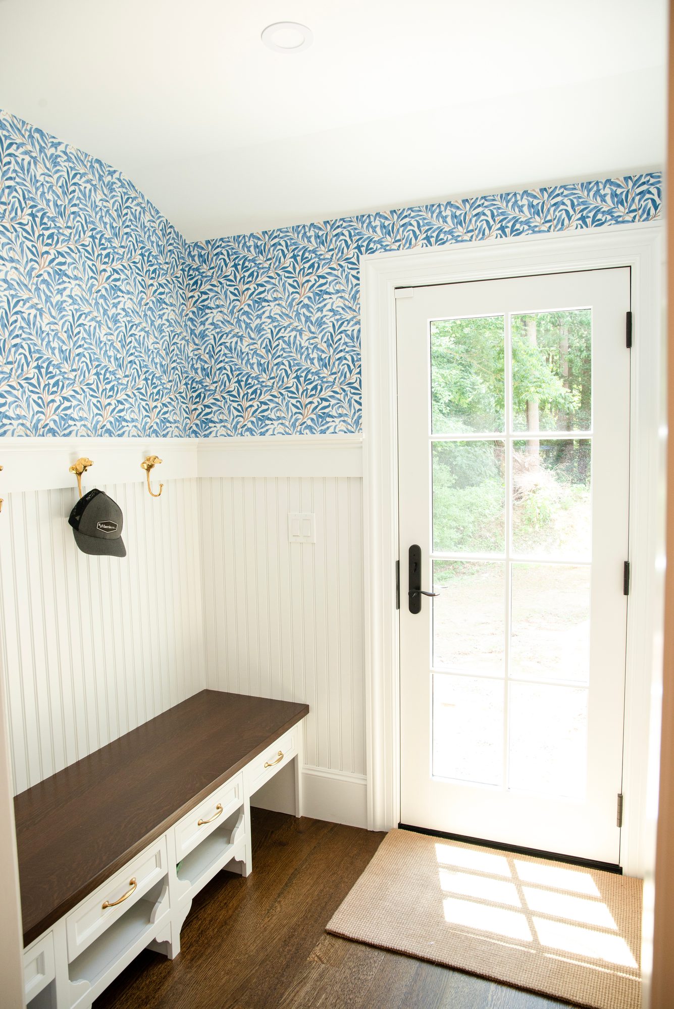 Wellesley Renovation — mudroom with patterned wallpaper, beadboard, and a garden door