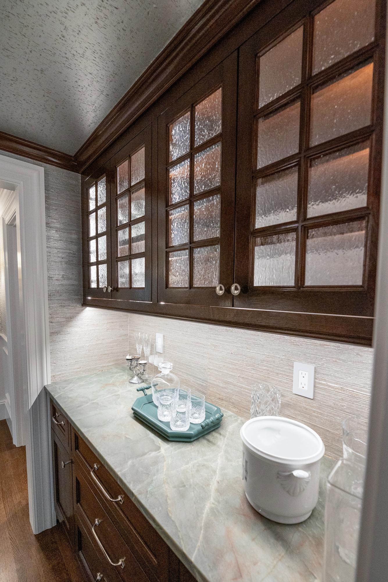 Wellesley Renovation — wet bar with glass-front upper cabinets and stone counter