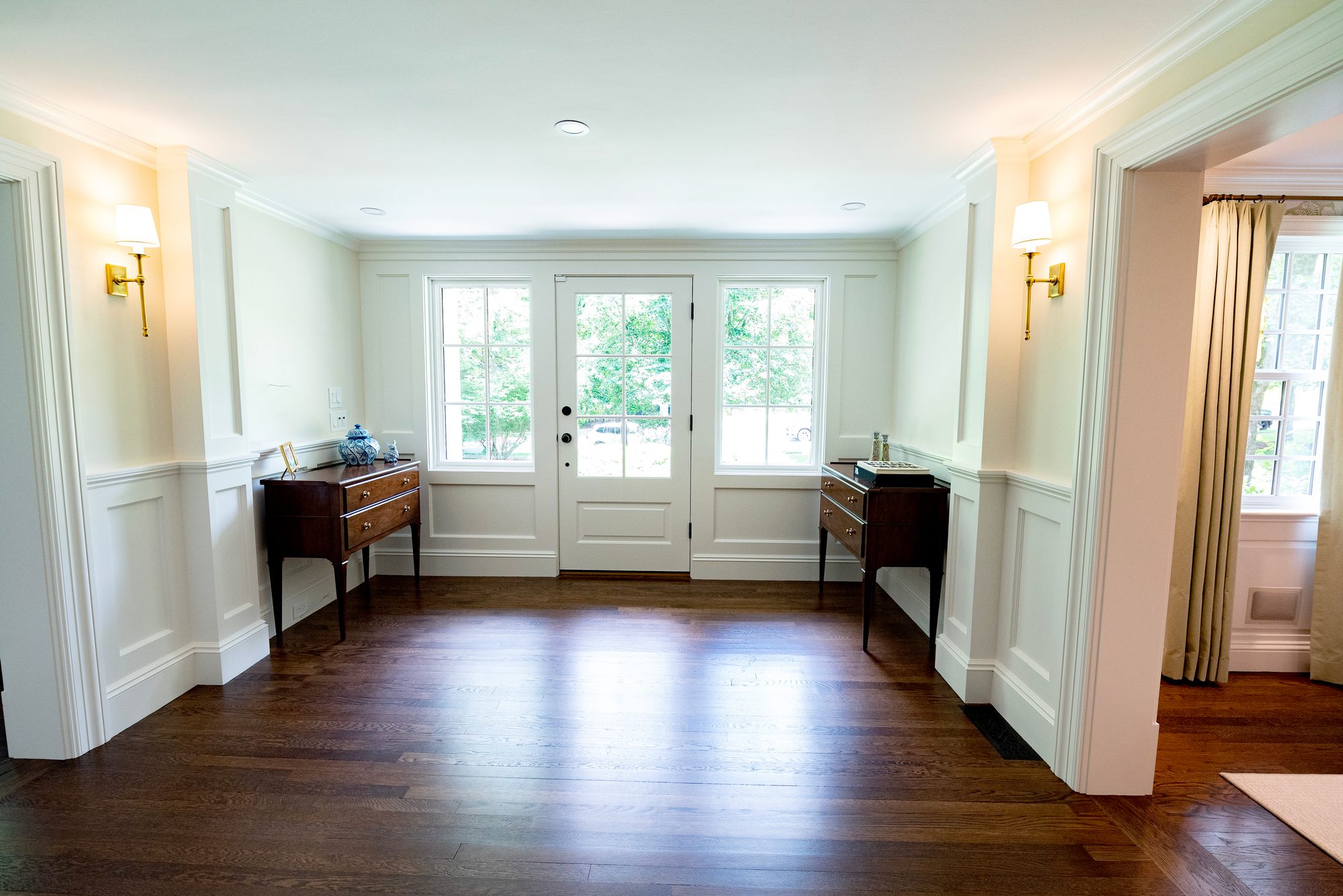 Wellesley Renovation — entry foyer with wainscoting and a pair of consoles