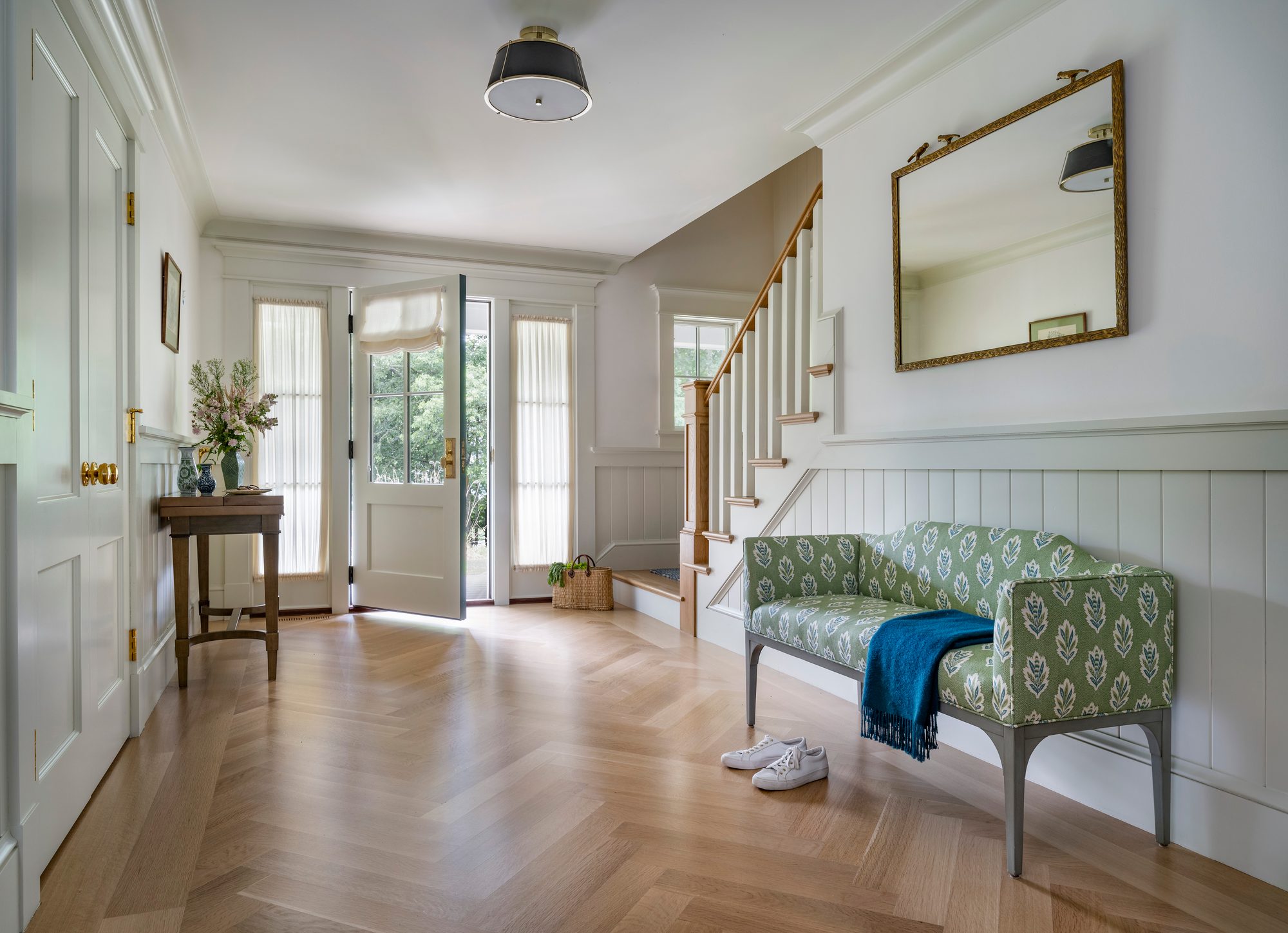 Westport Residence — entry foyer and stair with herringbone floor and a green settee