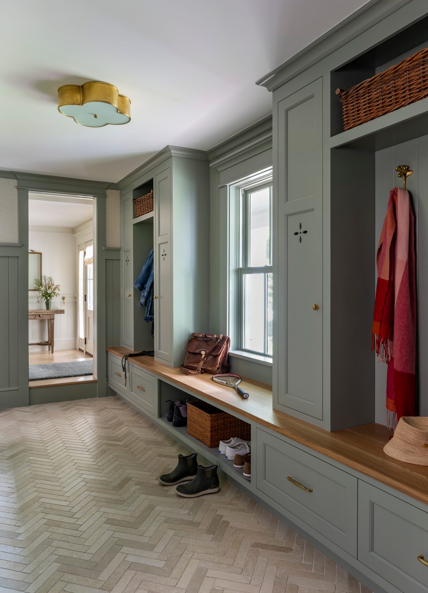 Westport Residence — mudroom with green built-in lockers, bench, and herringbone floor