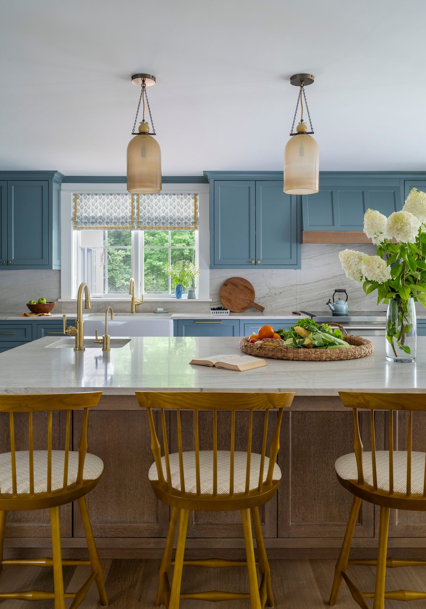 Westport Residence — kitchen island with counter stools beneath glass pendants