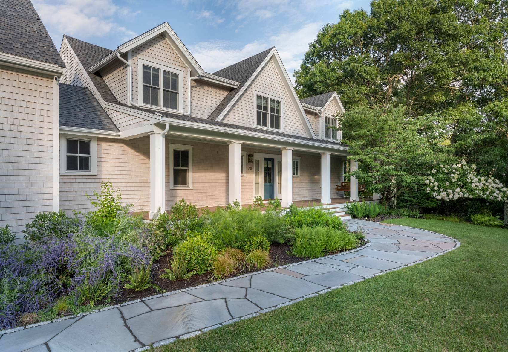 Westport Residence — front three-quarter view with the covered porch, plantings, and flagstone path